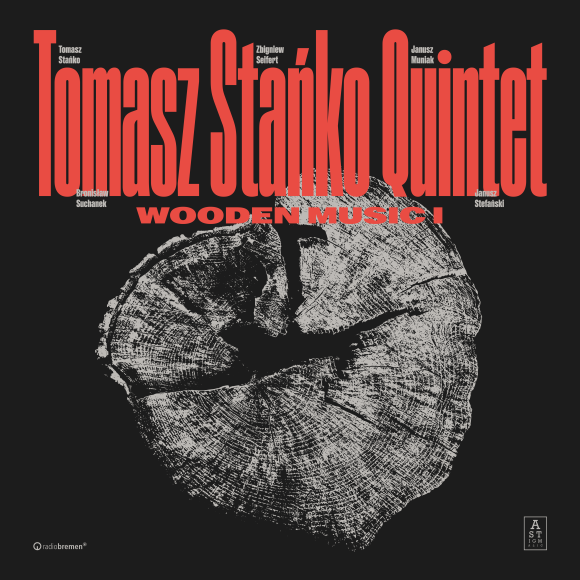 Na okładce znajduje się przecięte drzewo. Tło jest czarne, tytuł okładki Tomasz Stańko Quinted Wooden Music kontrastujący czerwony.