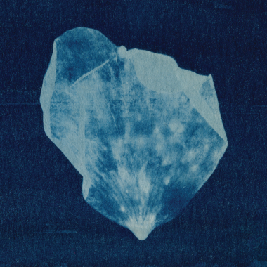 Niebieski kształt przypominający diament na granatowym tle.